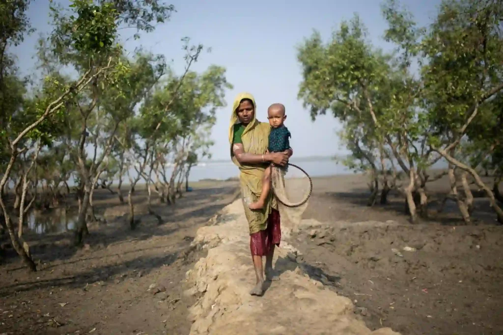 Sundarban village woman holding child walking on muddy road after bathing in river